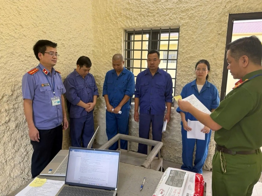 Cơ quan điều tra tống đạt quyết định khởi tố bị can đối với các đối tượng. Ảnh CQCA