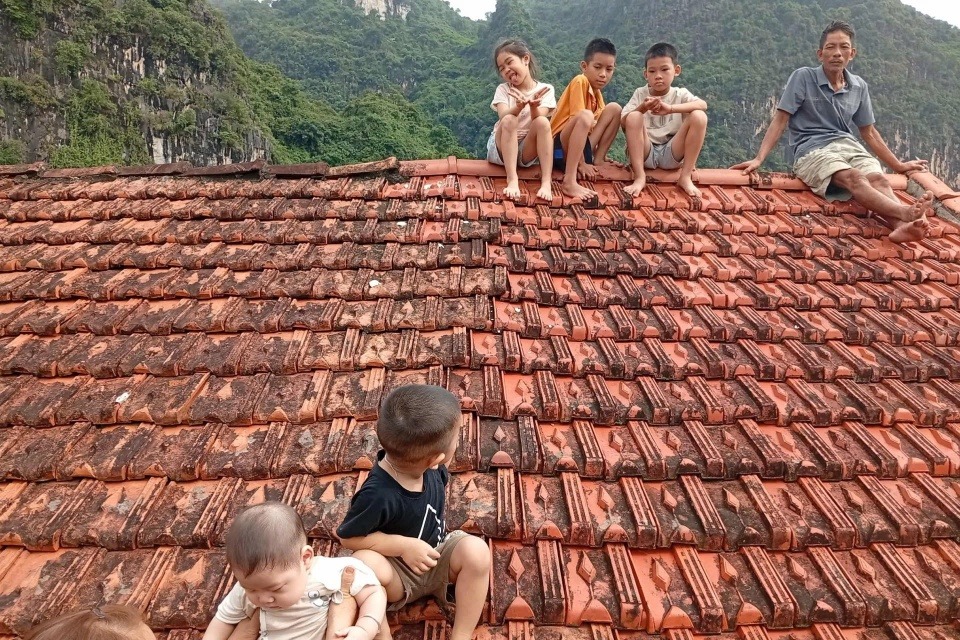5 đứa trẻ ở xã Vân Nham ngồi trên mái nhà chờ cứu hộ tiếp tế.