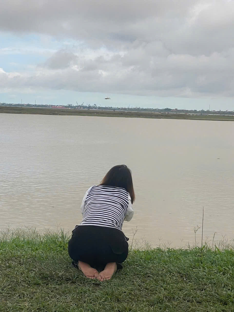 H&igrave;nh ảnh chị Y. quỳ lạy, cầu nguyện b&ecirc;n bờ s&ocirc;ng cầu mong hai con trở về