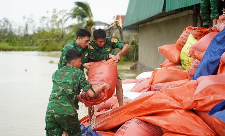 Cán bộ, chiến sĩ xuống các nơi để hỗ trợ người dân. Những bao lúa được đưa lên từ ao hồ, ướt sũng nước. Mục tiêu là hạn chế tối đa thiệt hại, giúp bà con sớm ổn định sản xuất sau bão. Ảnh: Báo Tiền phong